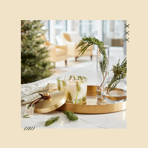 Thymes candle styled on a shelf with greenery to evoke seasonal atmosphere