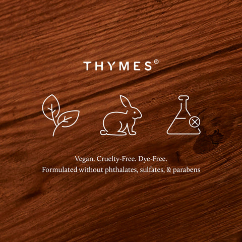 thymes candle placed near a fireplace creating cozy fall ambiance in room