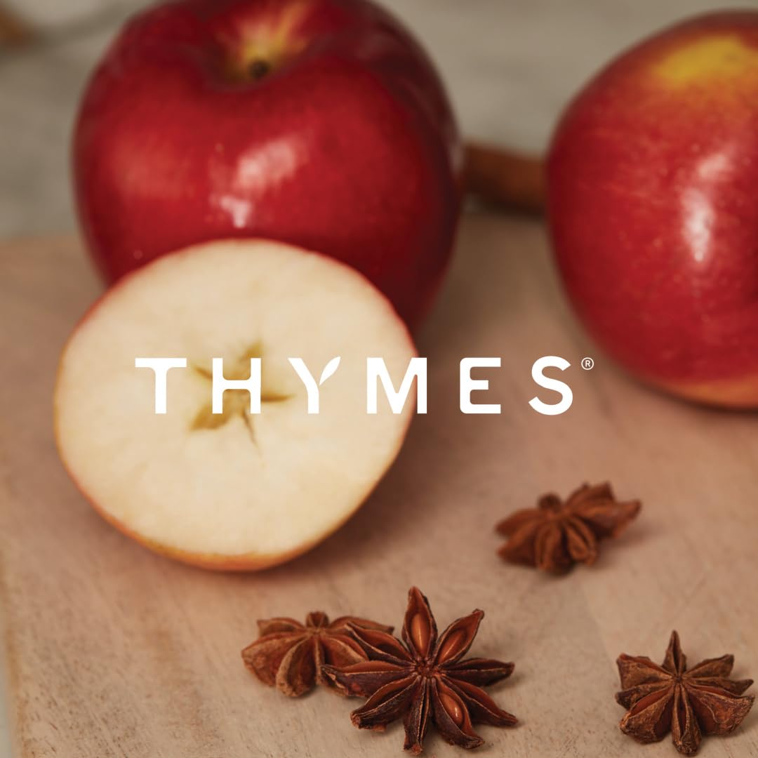 Thymes candle in seasonal display with fall decor enhancing room atmosphere