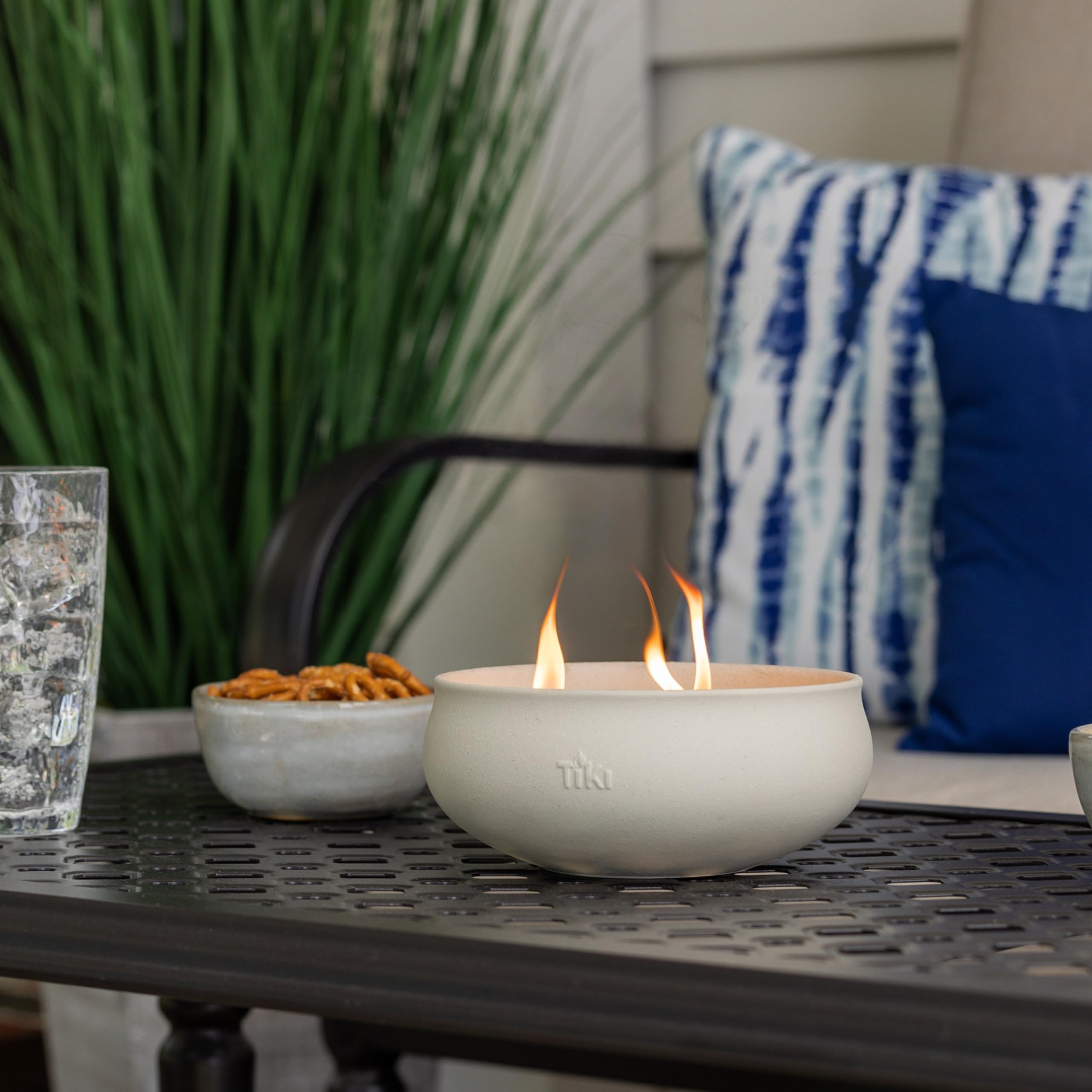 TIKI lit citronella candles on an outdoor dining table creating inviting evening ambiance