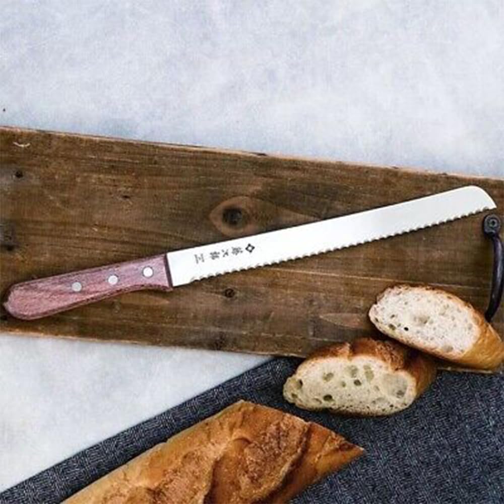 Tojiro knife beside a loaf for scale, illustrating 14.8 inch reach and control