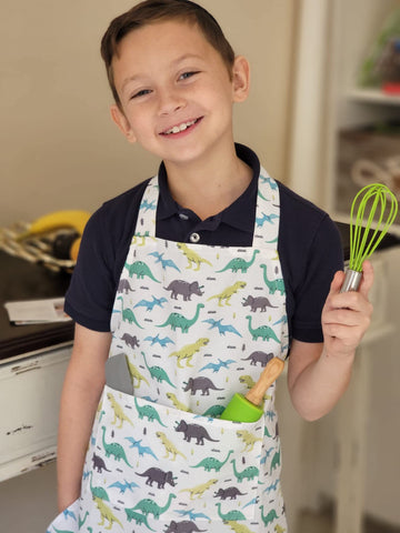 TOVLA JR. child using piping bags to decorate cupcakes with guidance