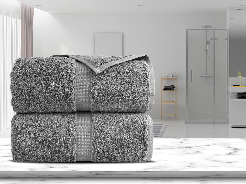Towel Bazaar size comparison next to bathmat showing generous 35x70 inch scale