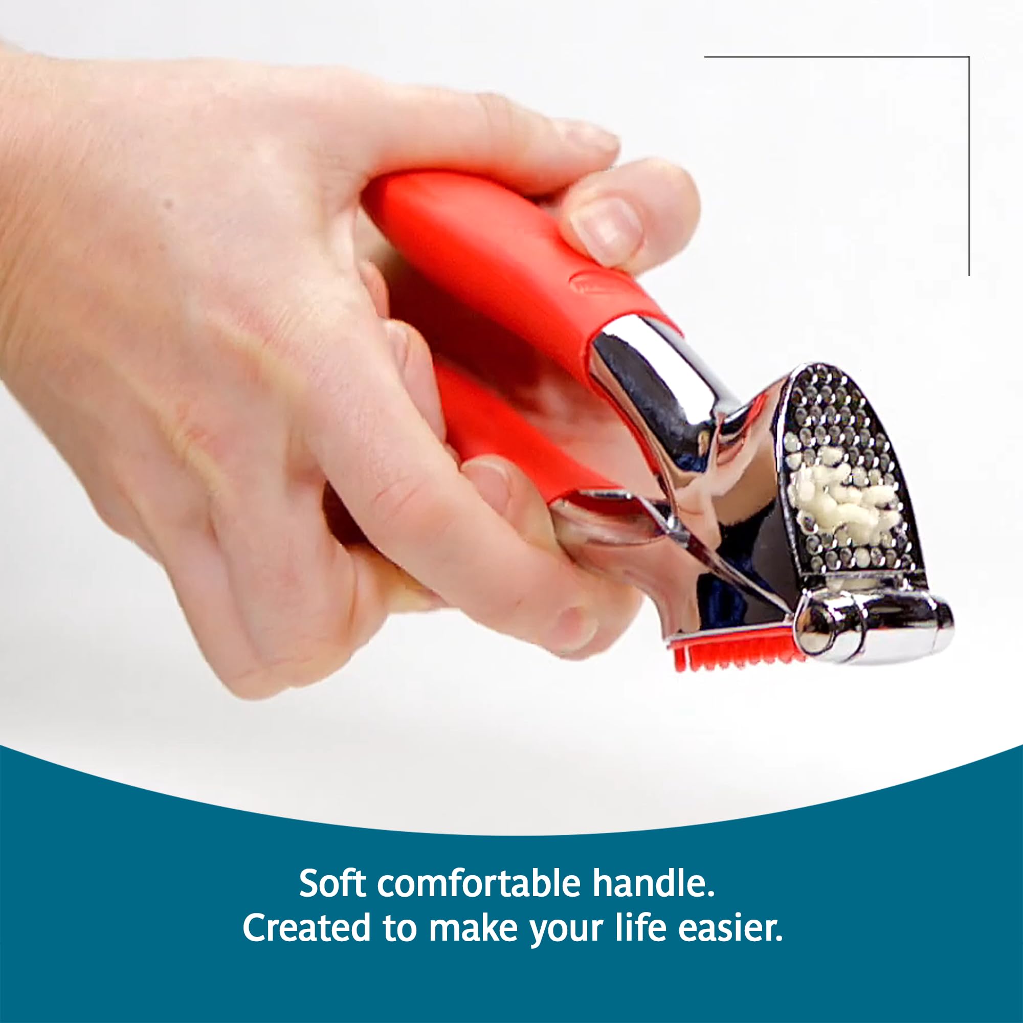 Trudeau garlic press in use over bowl producing finely crushed garlic