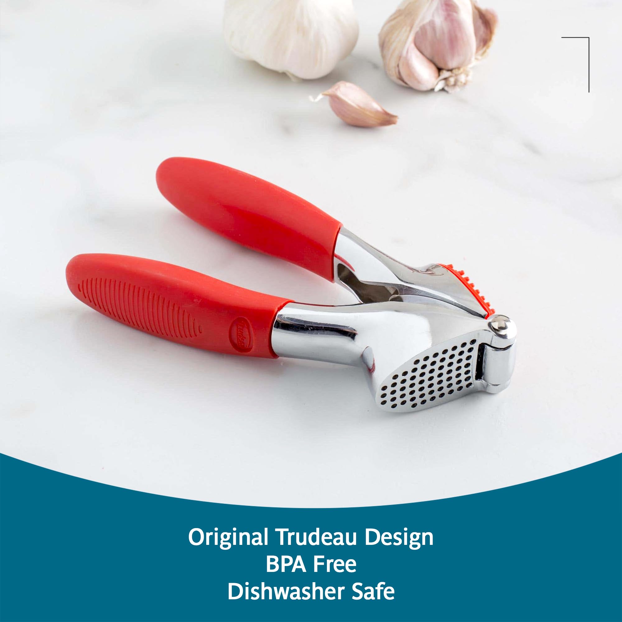 Trudeau garlic press beside garlic cloves showing scale and capacity