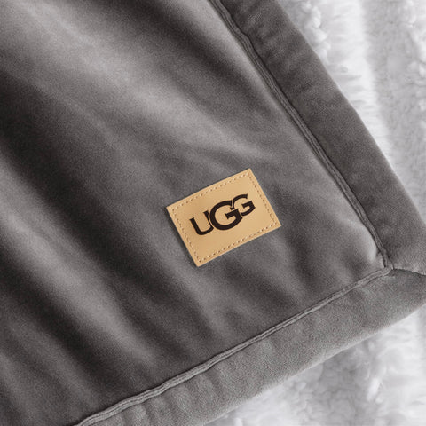 UGG layered at foot of bed offering stylish warmth and bedroom depth