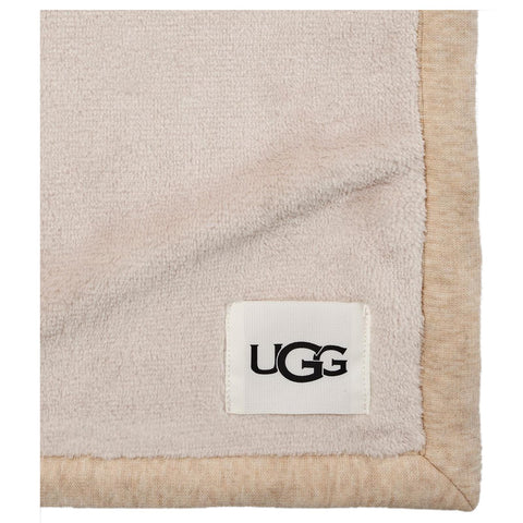UGG Duffield Throw draped on sofa in living room for warm ambiance