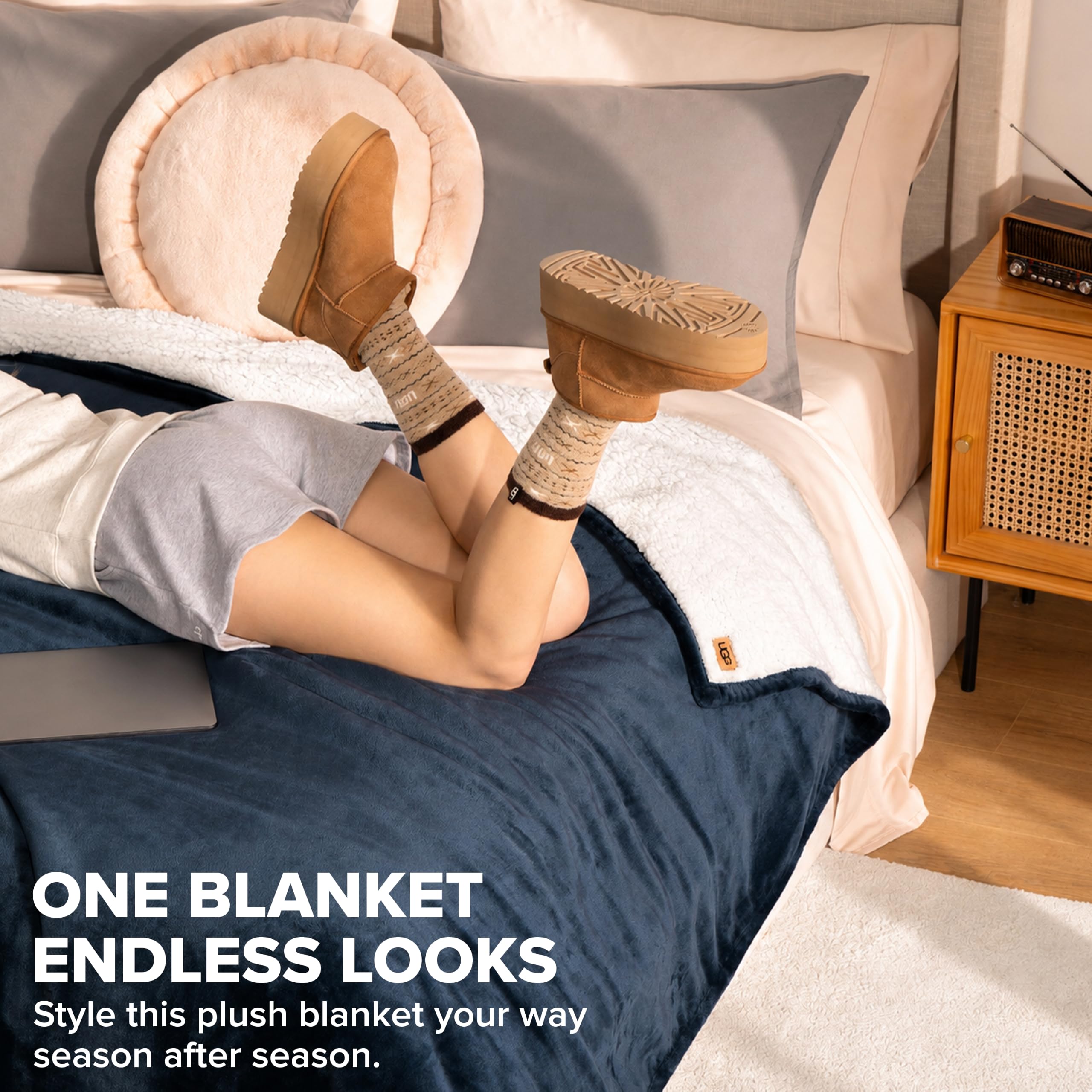 UGG Nita blanket styled on a queen bed adding elegant navy layering to bedroom