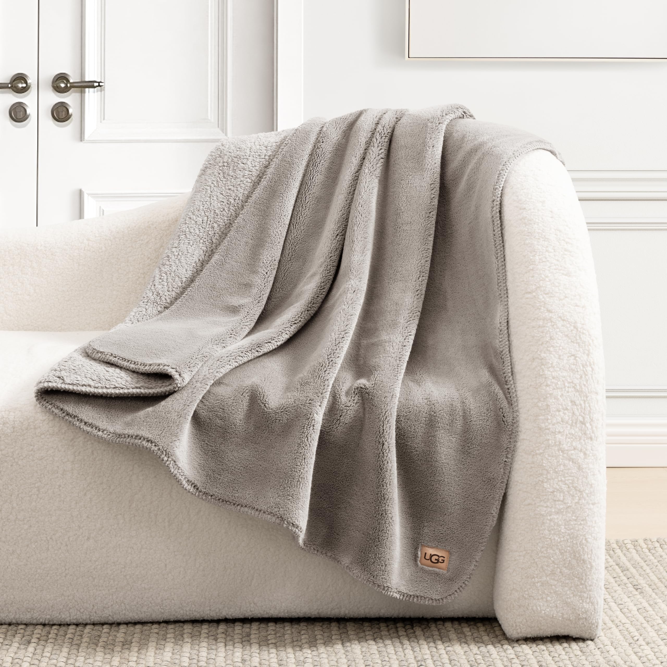 UGG Whitecap styled on bed showcasing neutral seal grey enhancing decor