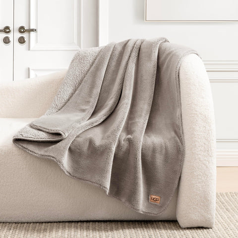 UGG Whitecap styled on bed showcasing neutral seal grey enhancing decor