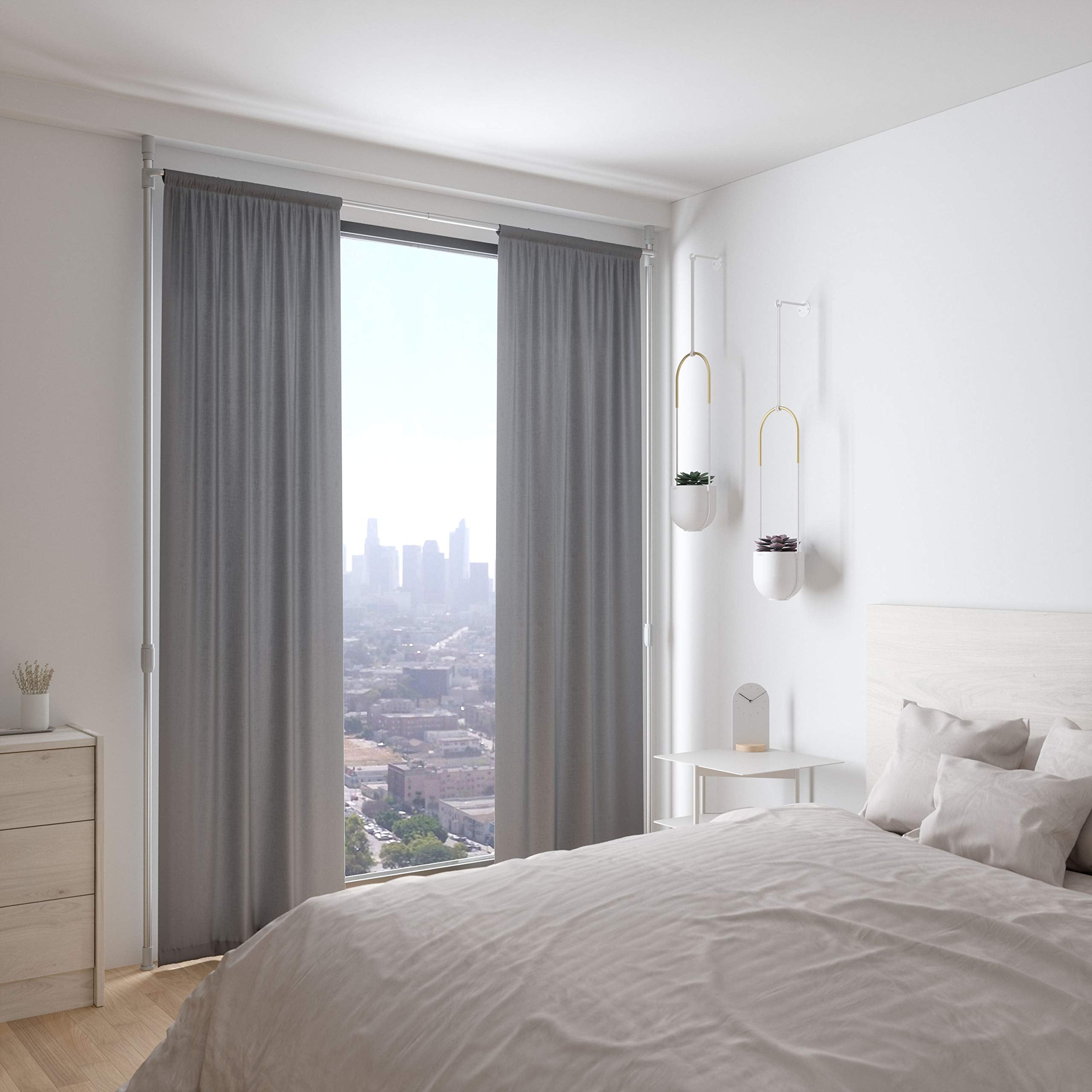Umbra curtain held flush against wall reducing light gaps for darker room