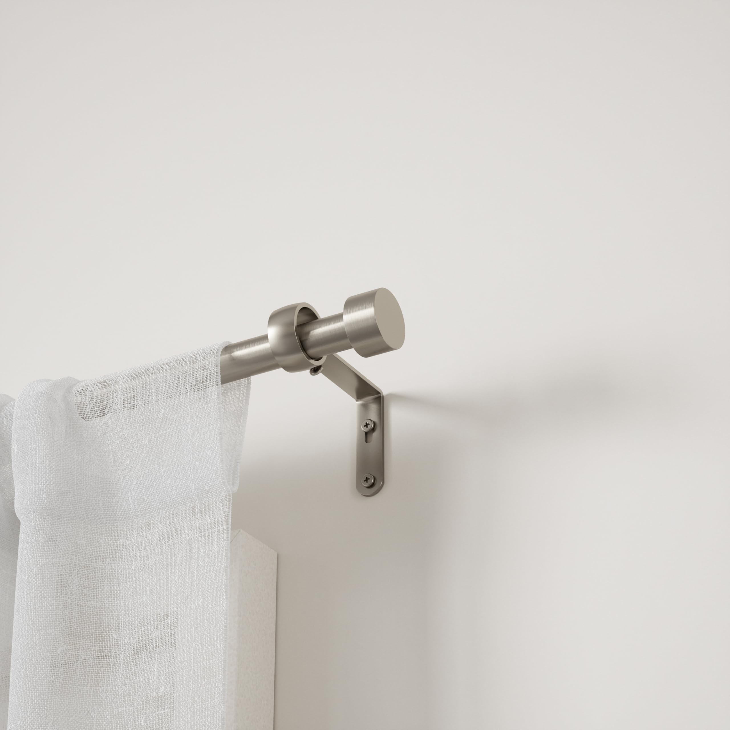 Umbra Cappa mounted with curtains in living room, shows neat supported drapery