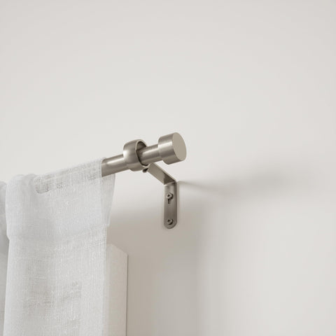 Umbra Cappa mounted with curtains in living room, shows neat supported drapery