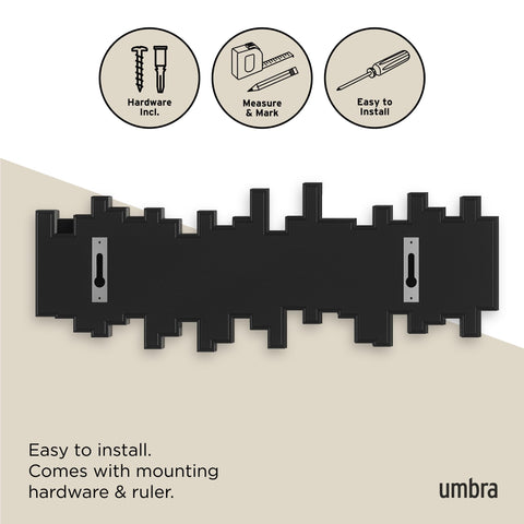 Umbra Sticks beside a hanging coat to show scale and practical capacity