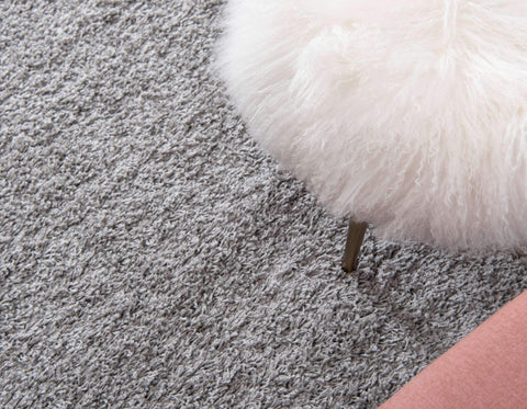 Unique Loom rug beside sofa illustrating size comparison and living room fit