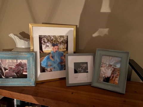 upsimples frame in hand for scale emphasizing lightweight, easy-to-hang convenience