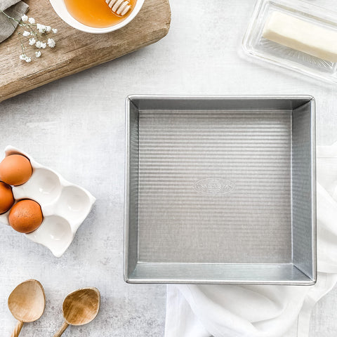 USA Pan with ruler illustrating 9 x 9 x 2.25 inch baking area for accurate sizing