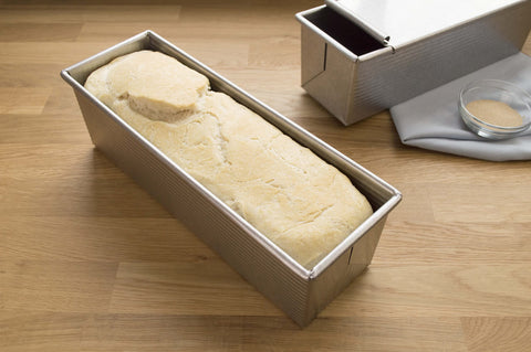 USA Pan pan beside ruler showing 9x4x4 scale for recipe planning and portion control