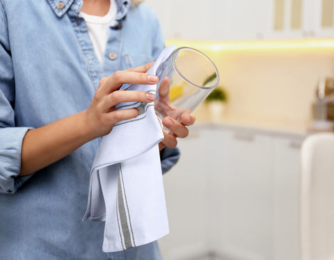 Utopia Towels drying a glass to show absorbency and streak-free benefit