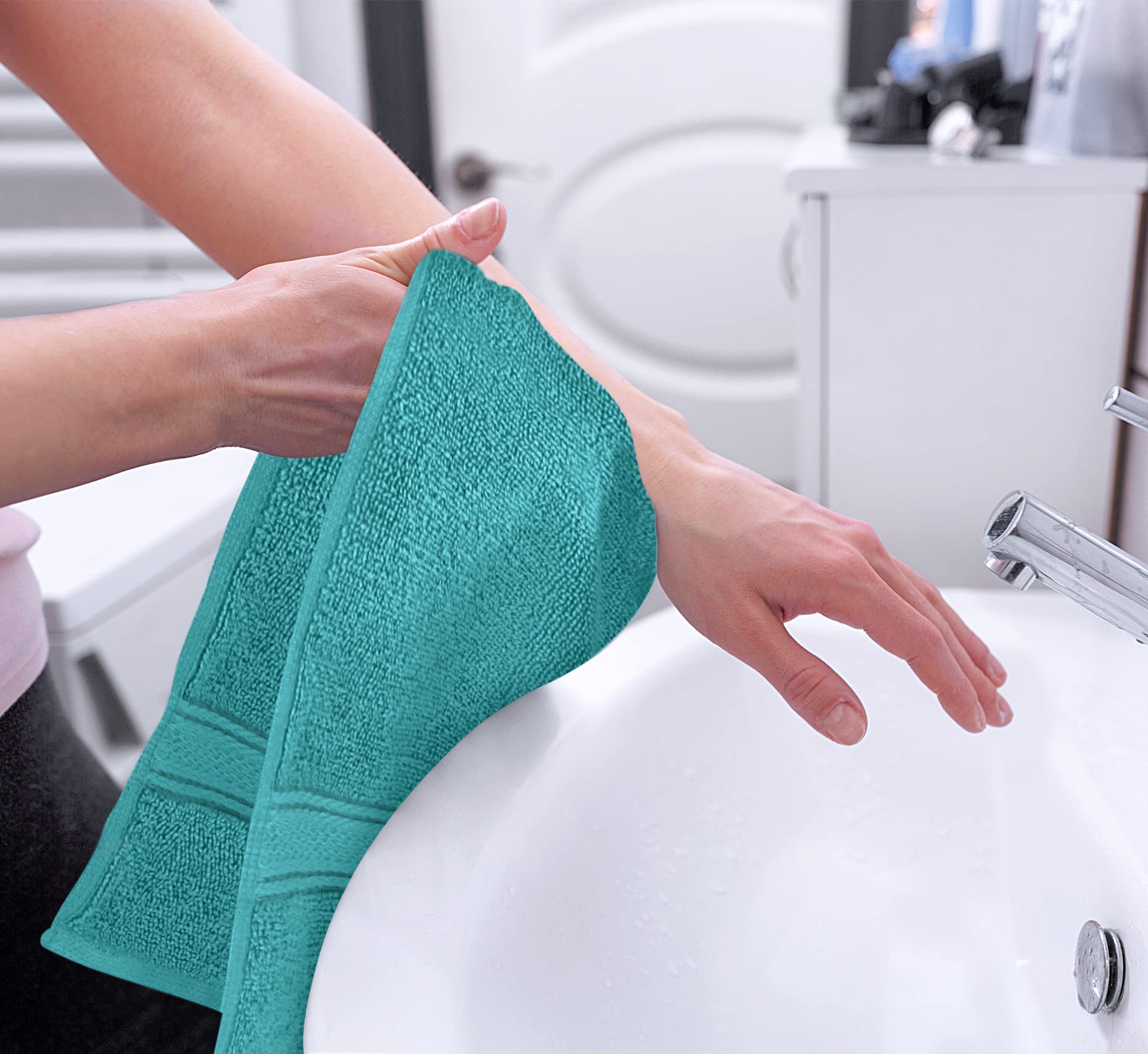 Utopia Towels folded stack on bathroom shelf adding coordinated color
