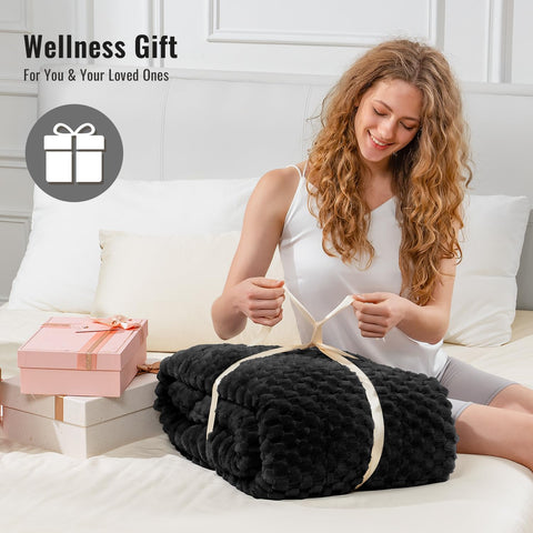 Uttermara folded blanket beside hands to show compact storage size