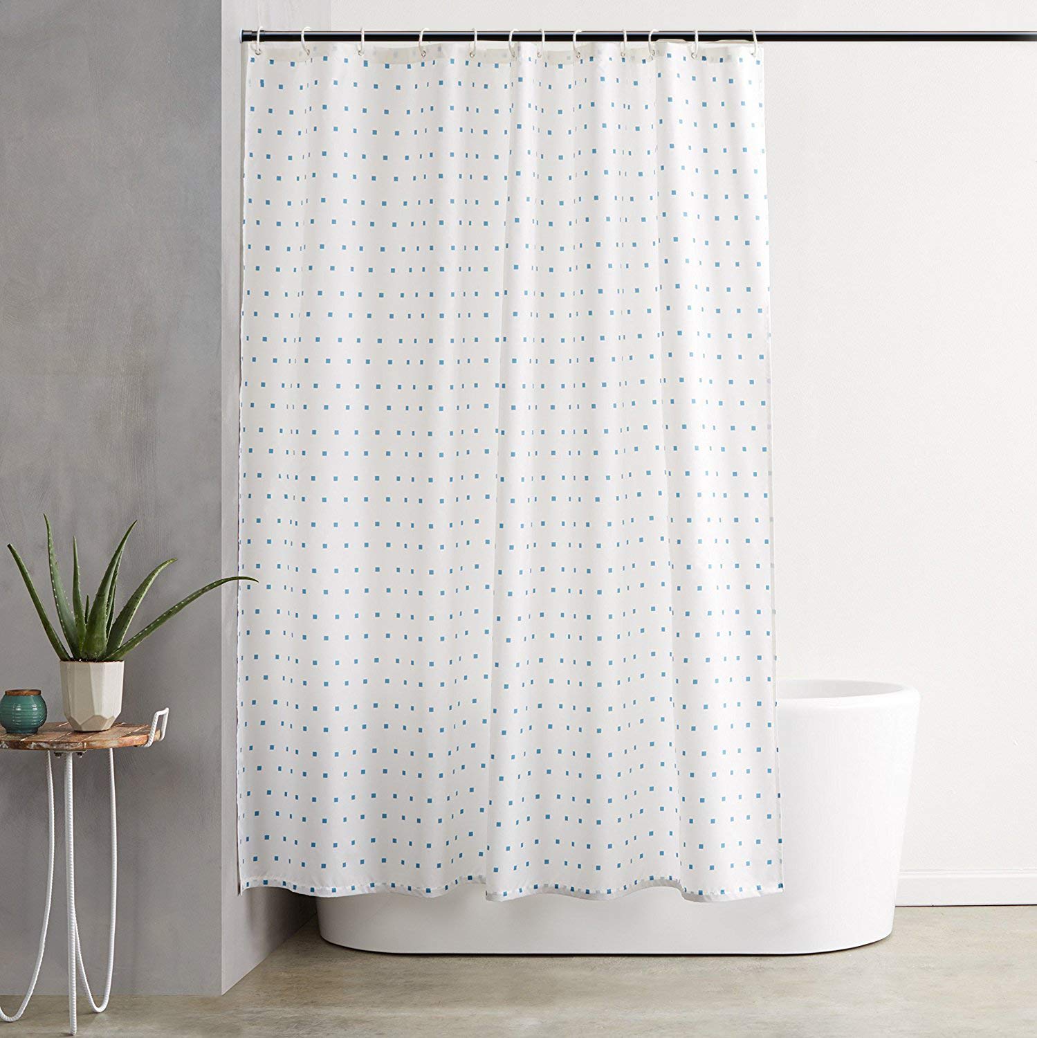 Vailge holding a heavy blackout curtain to demonstrate strong load-bearing capacity