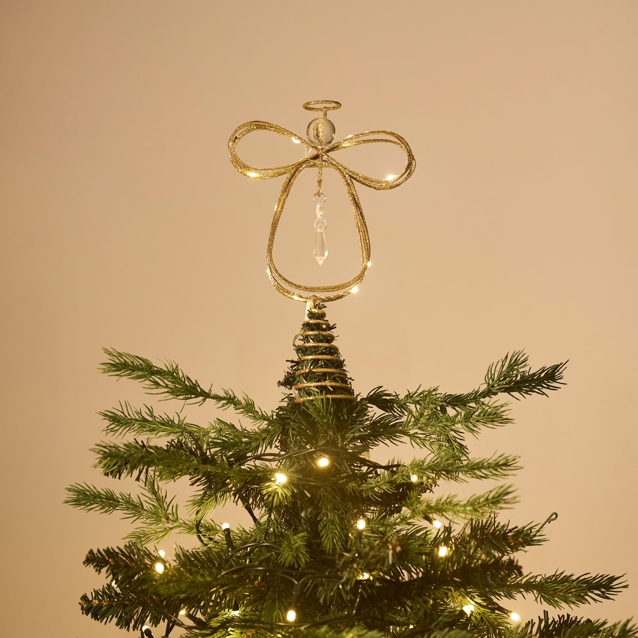 Valery Madelyn angel lit at night on tree creating warm ambient holiday mood