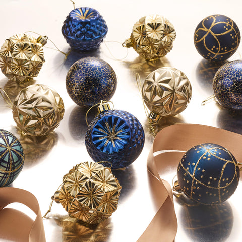 Valery Madelyn ornaments hanging on a lit tree adding cohesive blue and gold sparkle