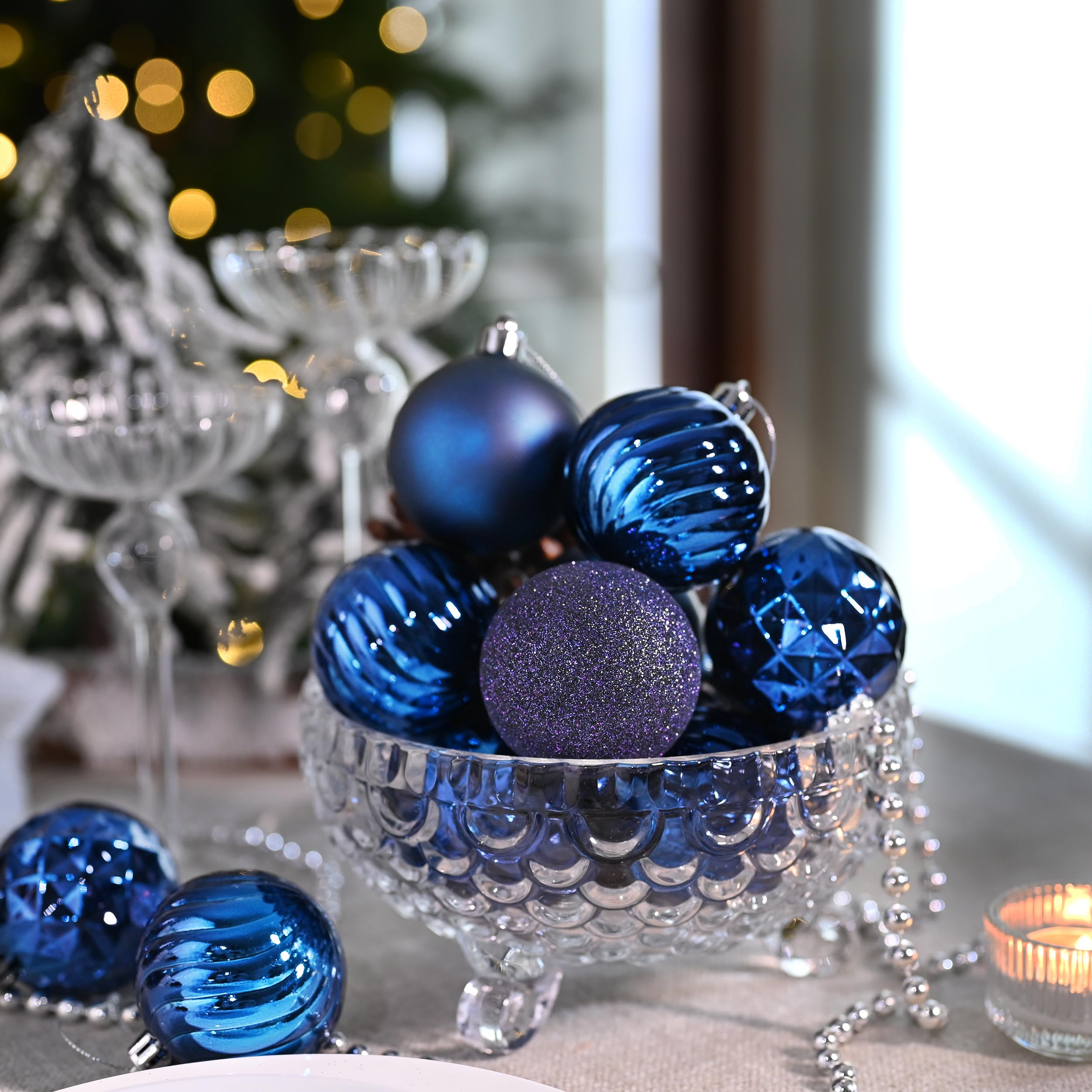Valery Madelyn ornaments hung on a tree creating layered navy contrast and festive depth