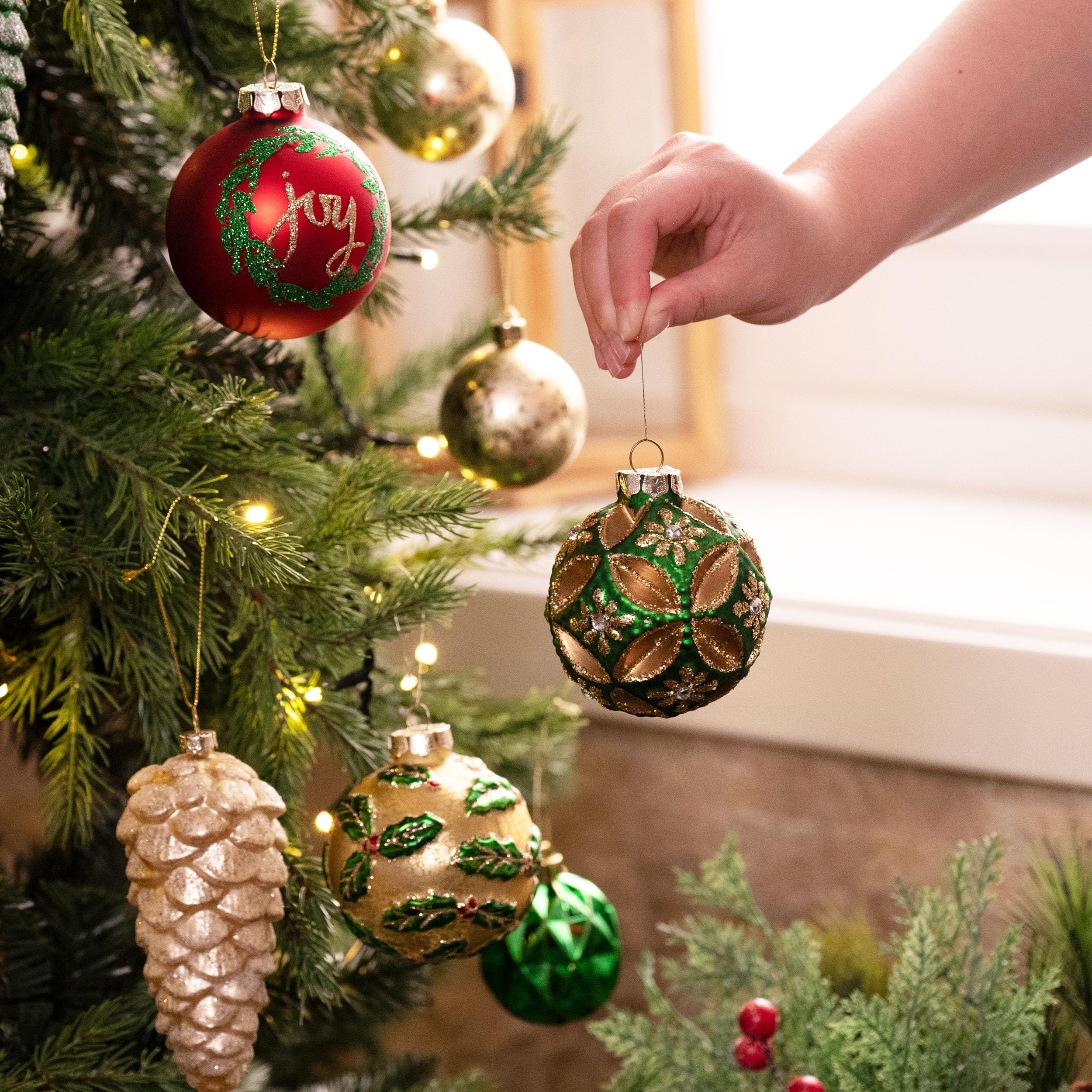 Valery Madelyn ornaments hung on a decorated tree showing cohesive holiday styling benefit