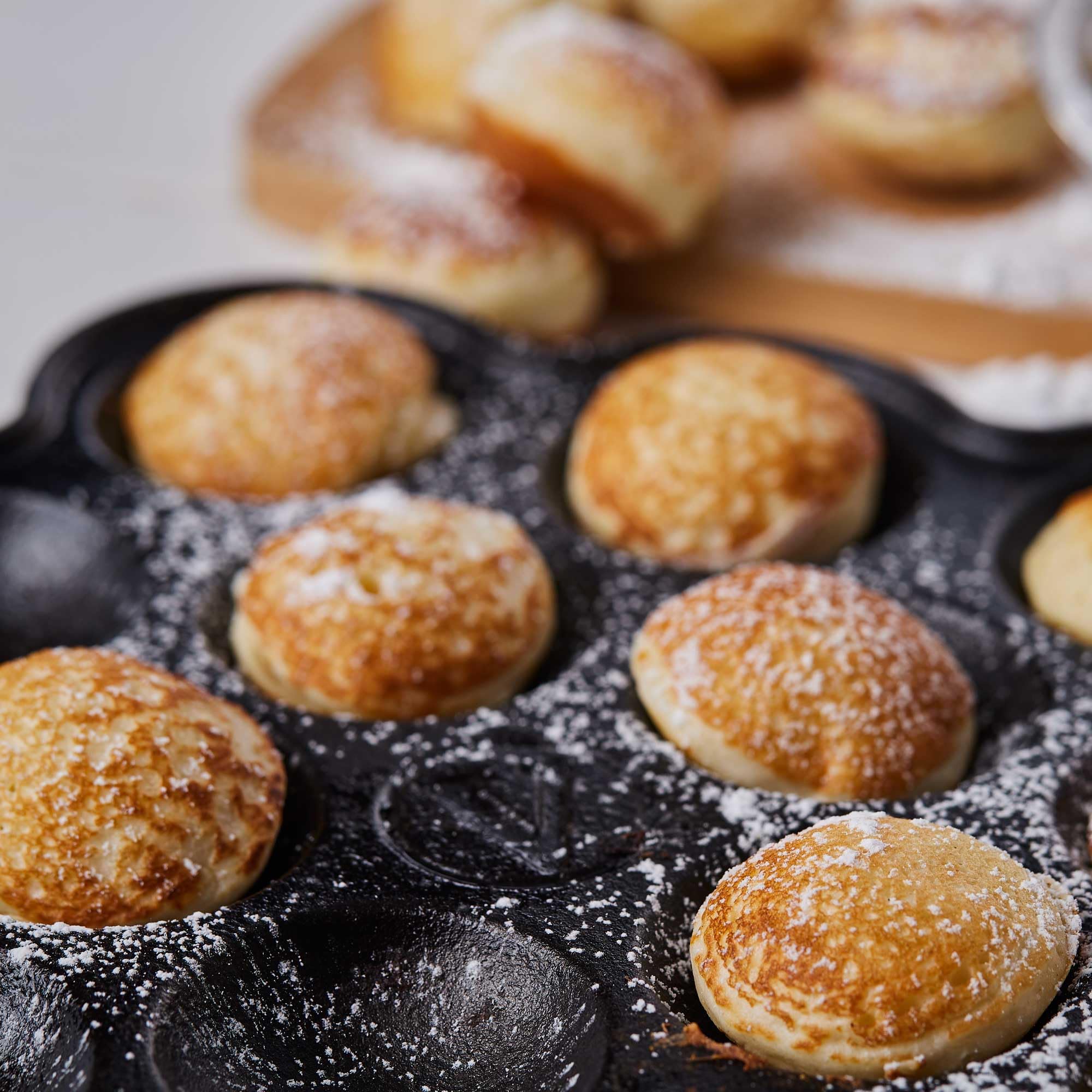 Victoria pan filled with golden poffertjes showing even cooking and presentation benefit