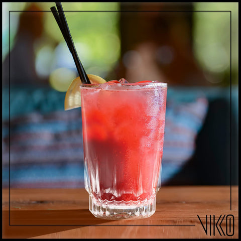 Vikko glass in child's hand with juice demonstrating safe small portion use.