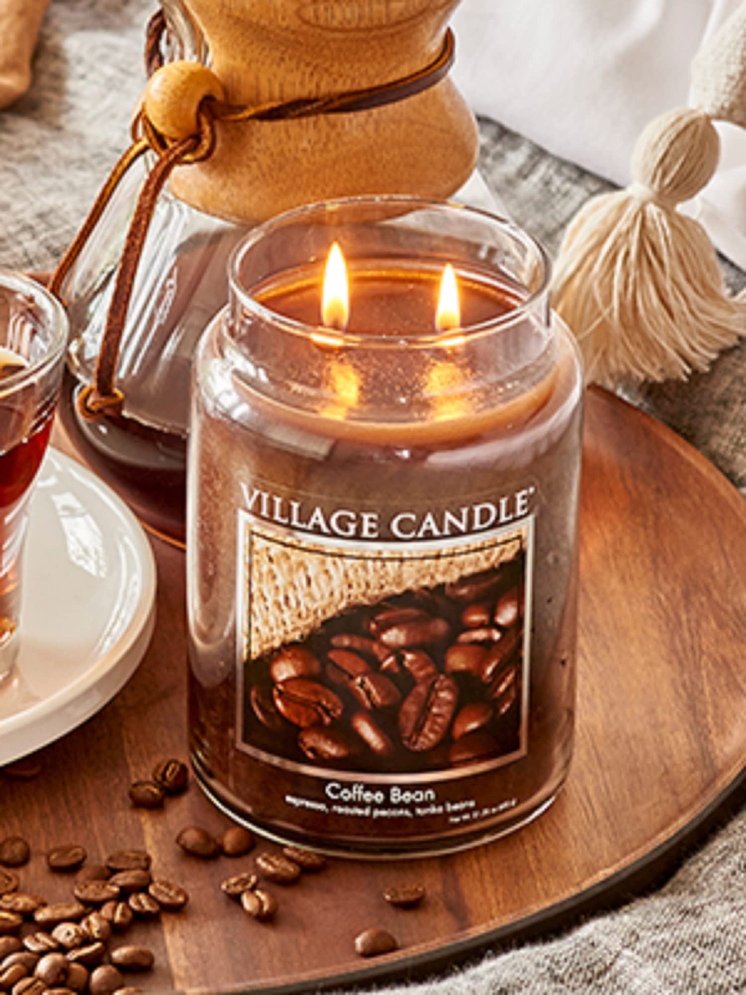 Village Candle held next to hand to show large 21.25 oz scale and long-lasting burn