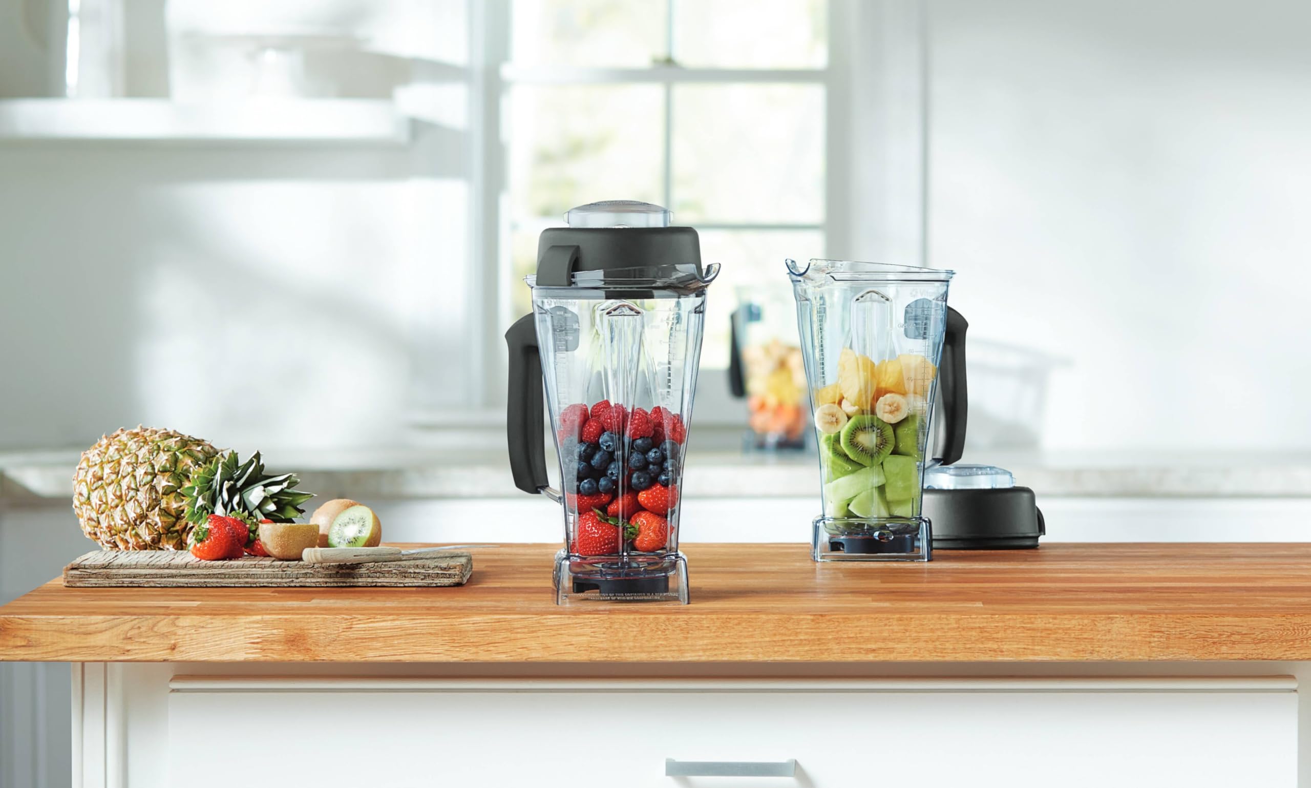 Vitamix 64 oz container next to a coffee mug to show capacity and household scale benefits