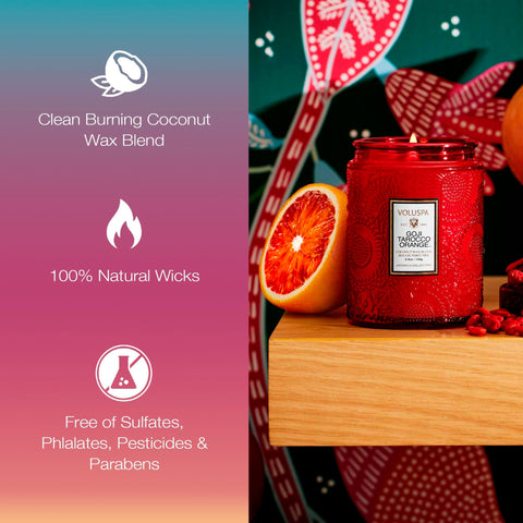 Voluspa candle lit on bathroom shelf creating ambient citrus-fruit warmth