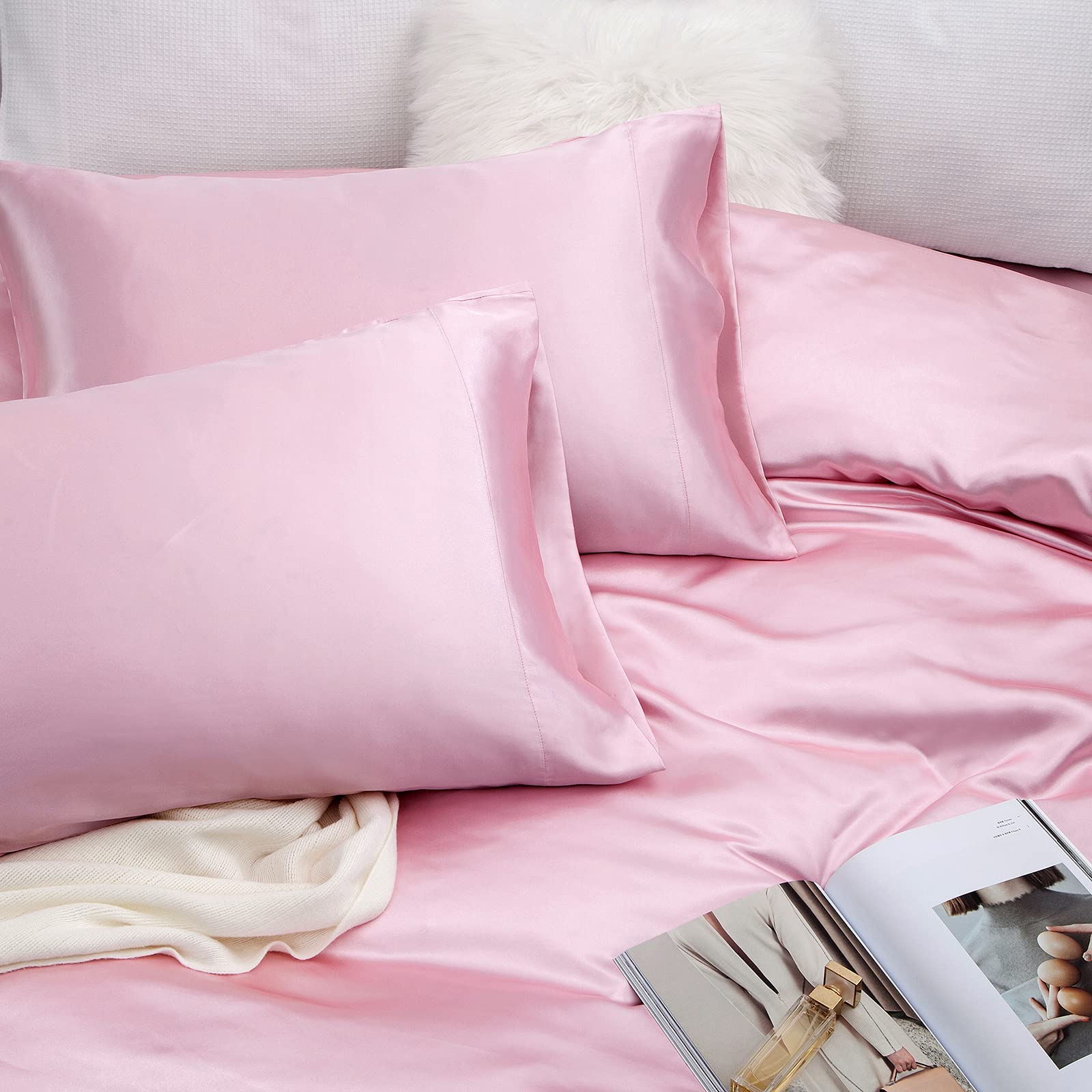 Vonty styled bedroom with pink satin sheets creating an upscale, cozy atmosphere