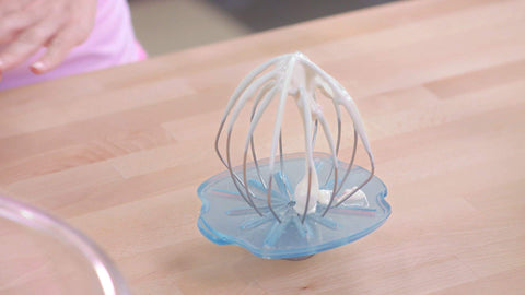 WHISK WIPER on tilt-head mixer wiping whisk to reduce mixing mess benefit