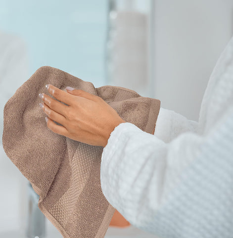 White Classic towels on a spa shelf with candles conveying luxury and relaxation