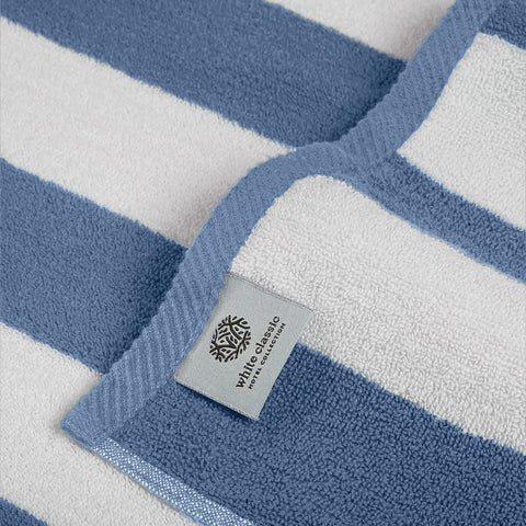 White Classic towel laid on sand beside shore showing portability and beach-ready style