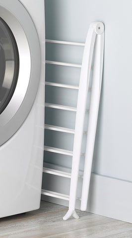 Whitmor Spacemaker folded flat stored beside washer showing compact storage benefit