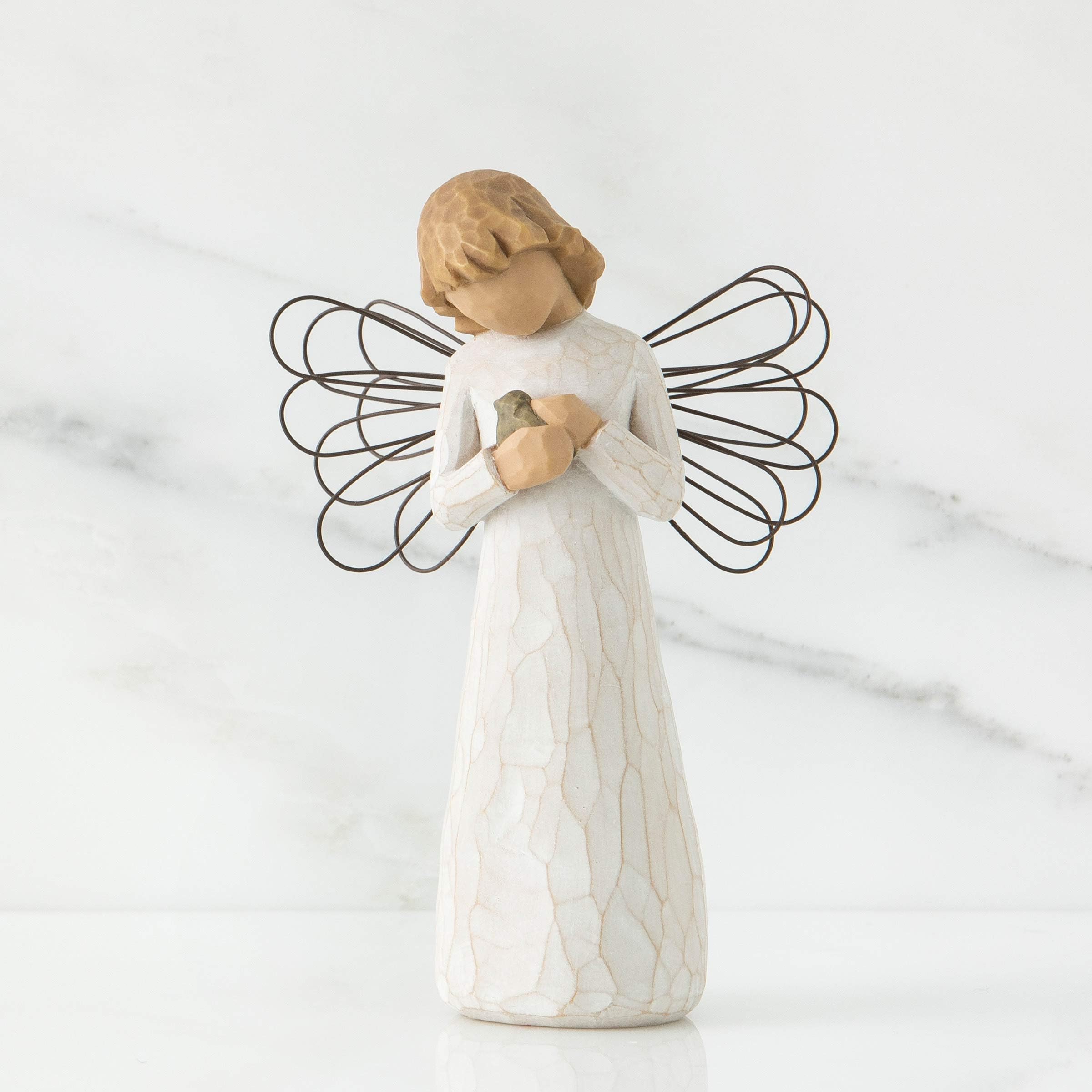 Willow Tree close-up of angel holding blue-gray bird highlights delicate detail and hope