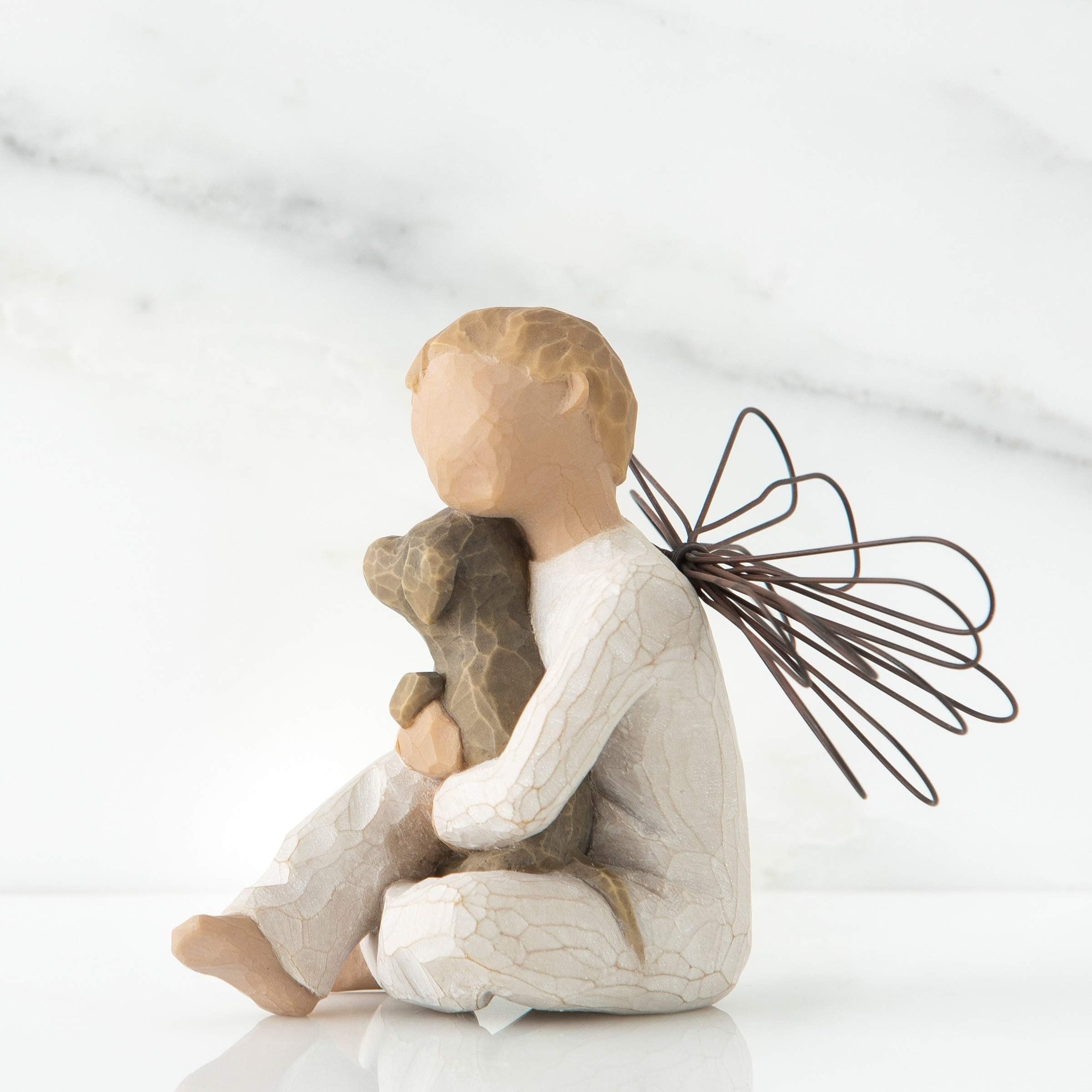 Willow Tree detail of seated boy angel holding brown dog, evokes tenderness