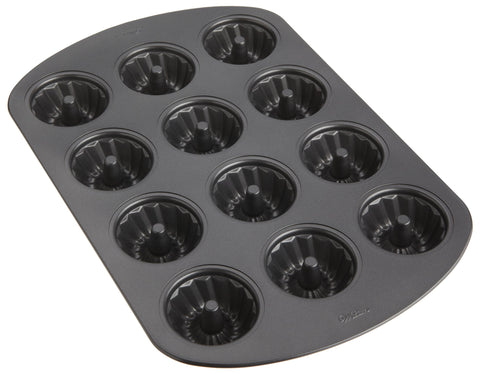 Wilton pan filled with baked mini fluted cakes demonstrating clean release