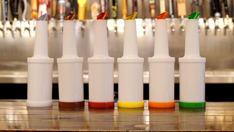 Winco bottles lined on a bar counter in use for faster service and organized dispensing