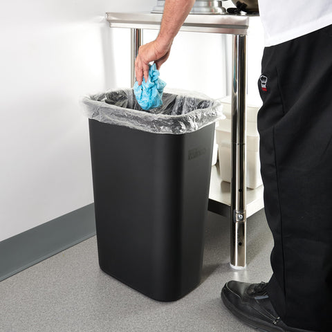 Winco waste basket placed under desk in office to save space and stay tidy