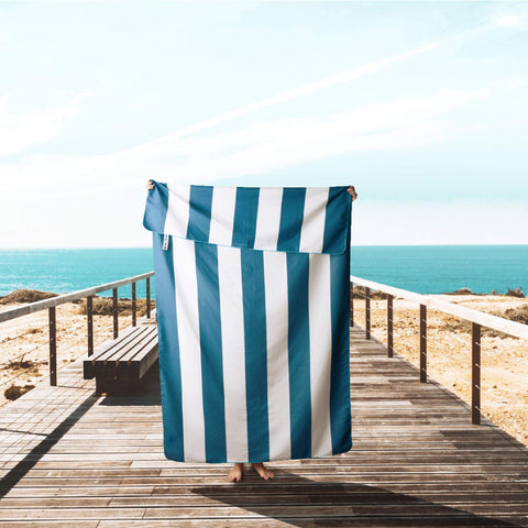 Wise Owl Outfitters towel being shaken to remove sand, keeping it clean and light
