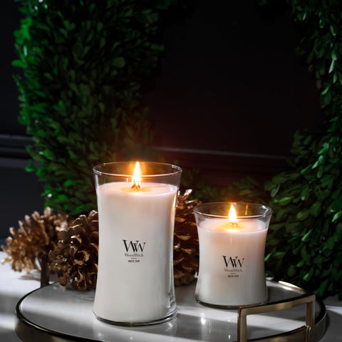 WoodWick hourglass candle beside a book for scale showing size and long-lasting burn benefit