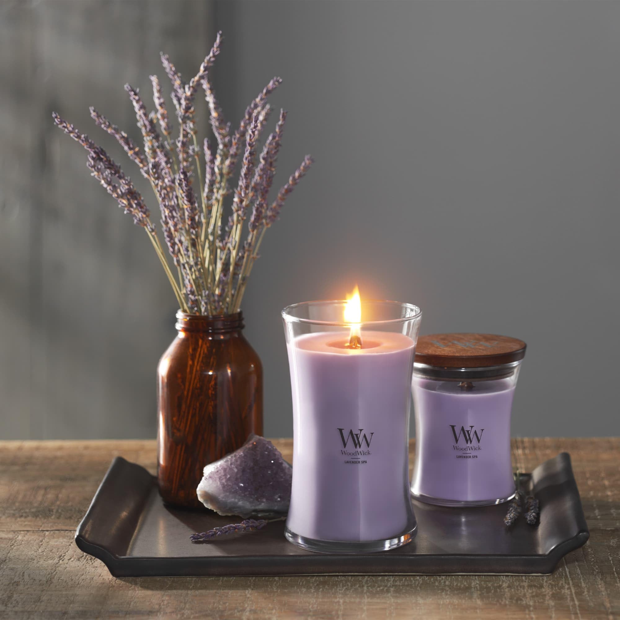 WoodWick candle beside common objects showing scale and medium 9.7 oz convenience benefit