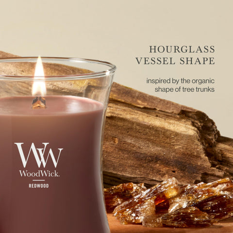 WoodWick candle held in hand showing medium 9.7 oz scale benefit