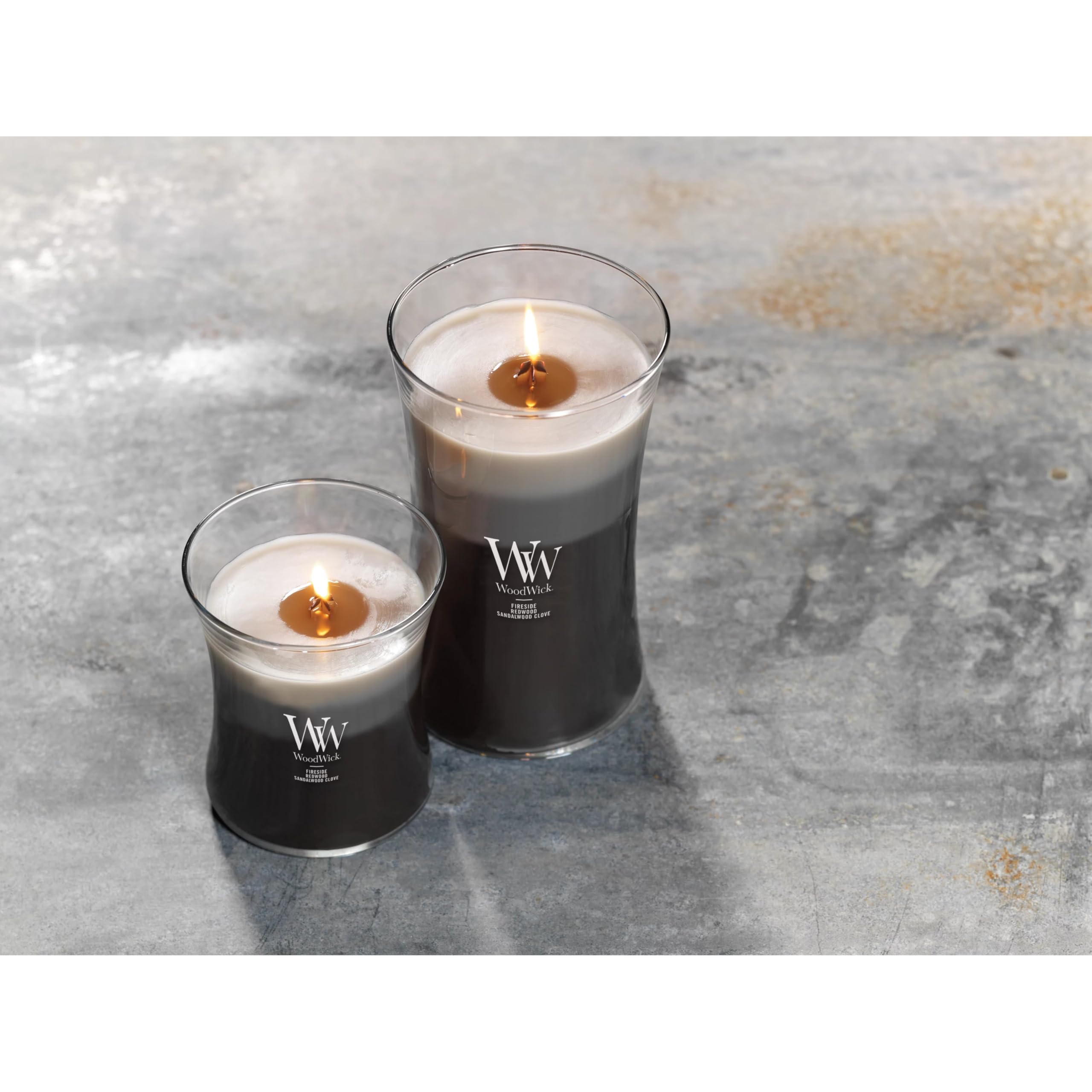 WoodWick candle next to book showing 21.5 oz scale and long-lasting burn